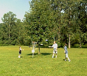 Bill, Jeff & Joe playing frisbee golf - see the frisbees in the air?
